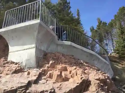 Custom curved iron railing on cliffside concrete staircase